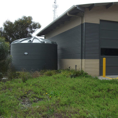 Polymaster 31700L Round Rainwater Tank Installed Next To a business