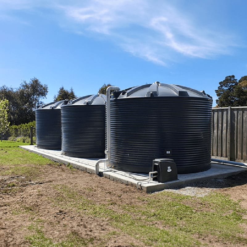 Three Polymaster 22500L Round Rainwater Tanks in Dark Blue