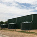 three Polymaster 31700L Round Rainwater Tanks next to a big shed