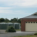 three Polymaster 31700L Round Rainwater Tanks next to a residence